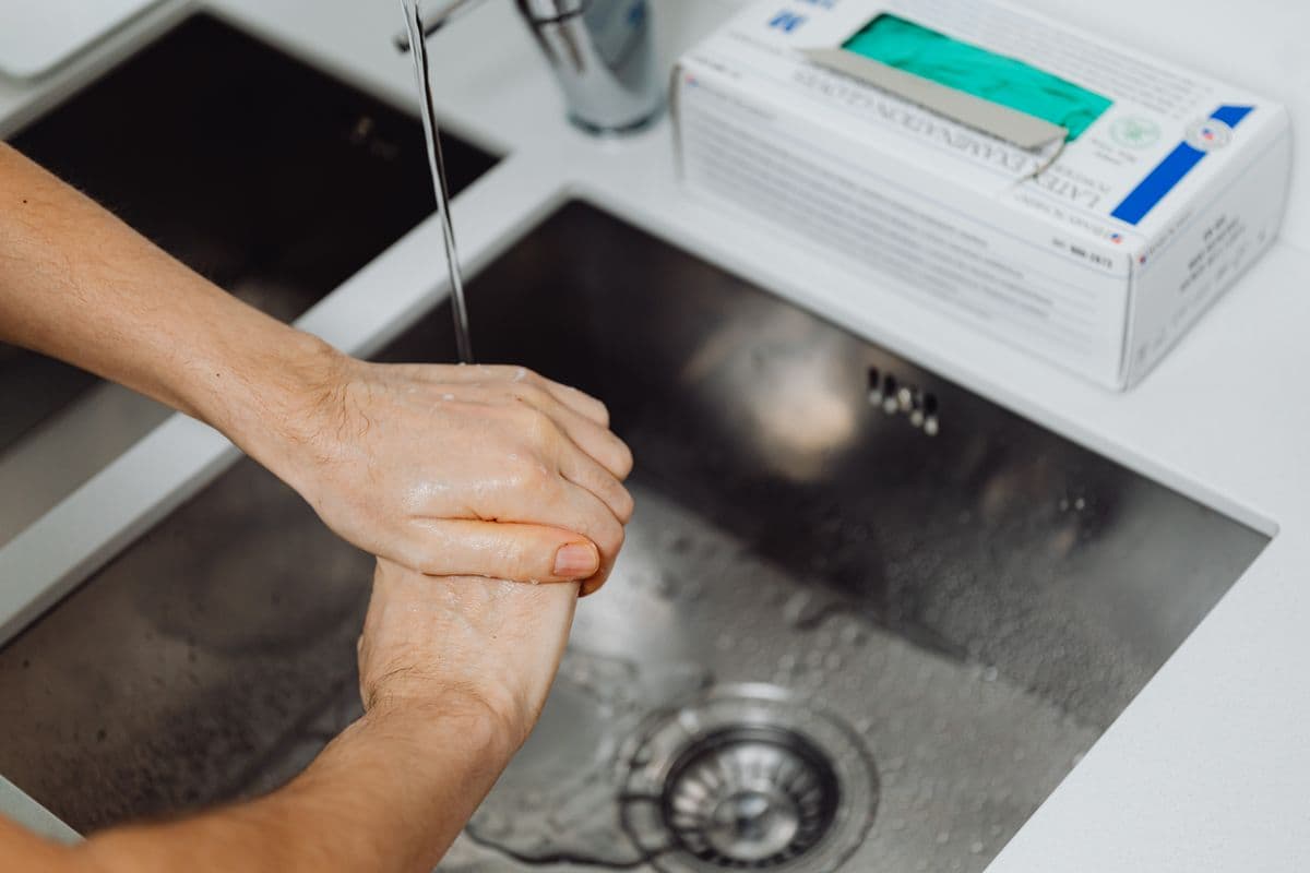 Hands being washed under running water.